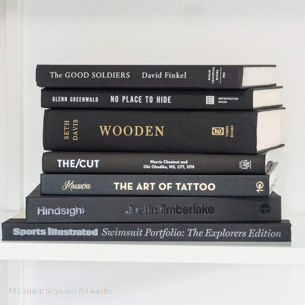 Stack of black hardcover books used for decorating bachelor pad.