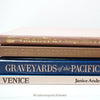 Stack of hardcover books in navy blue and neutral colors. Real books staged and used for decorating.