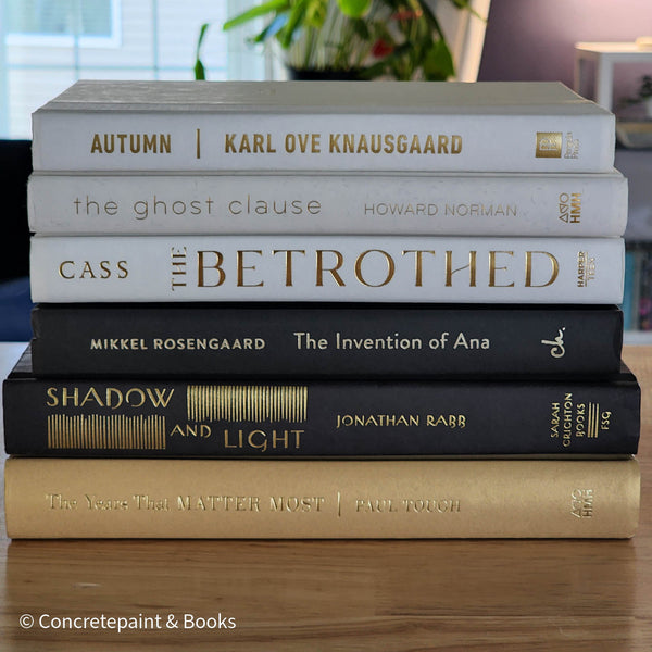 Stack of gold, black, and white book display. Real books used for modern and glam decorating. 
