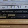 Stack of gold, black, and white book display. Real books used for modern and glam decorating. 