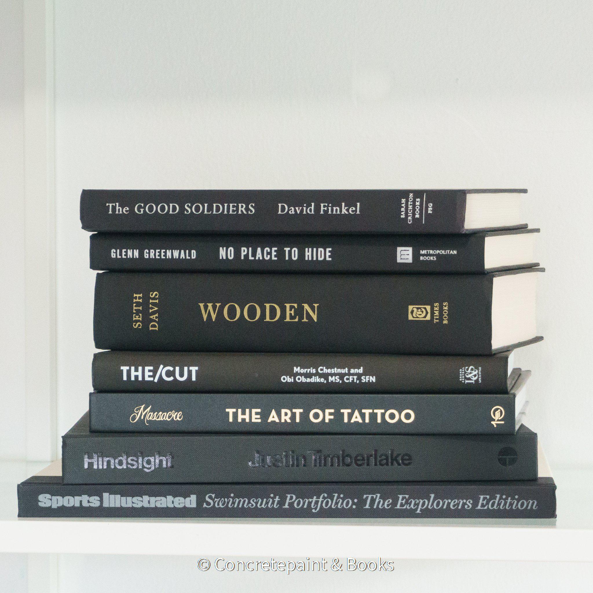 All black real books used as home décor. Stack of all black hardcover books including coffee table books, and novels.