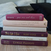 Stack of burgundy, blush, and neutral color books. Real hardcover books used for decorating.