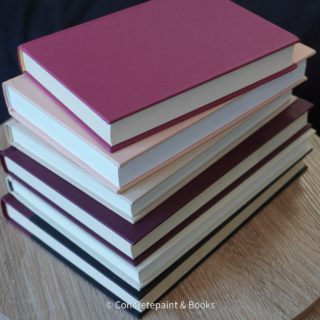 Stack of burgundy, blush, and neutral color books. Real hardcover books used for decorating.