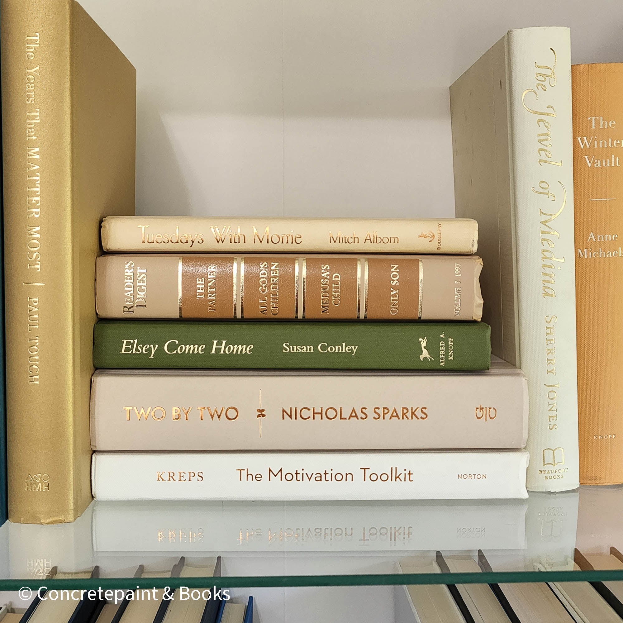 Olive green and neutral books used as shelf decor. Set of books for reading and decorating.