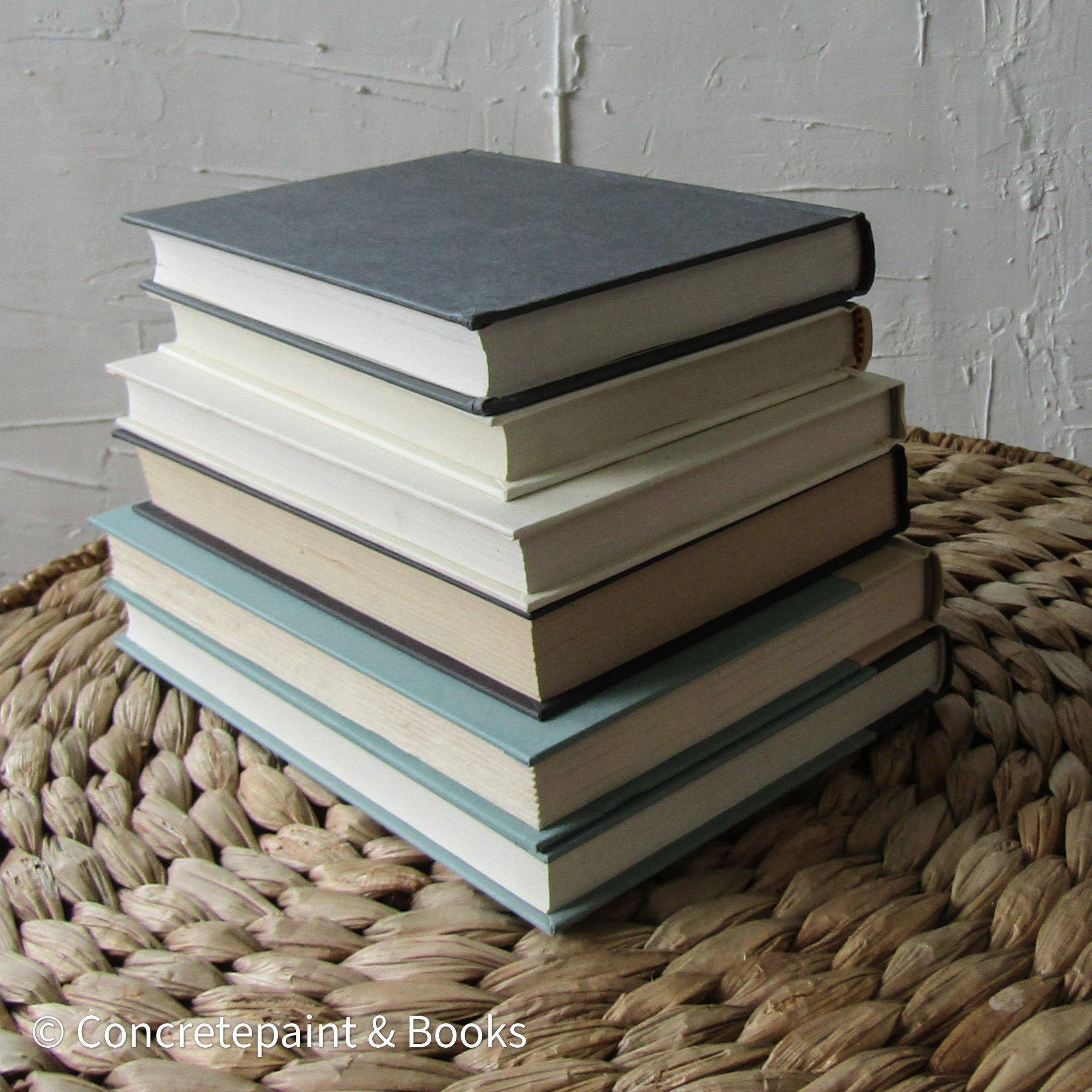 Set of hardcover books in gray, mint green,  neutral colors staged and used as decorating home display. 