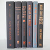 Stack of black and gray hardcover books with copper font. Real books staged and used as shelf décor.