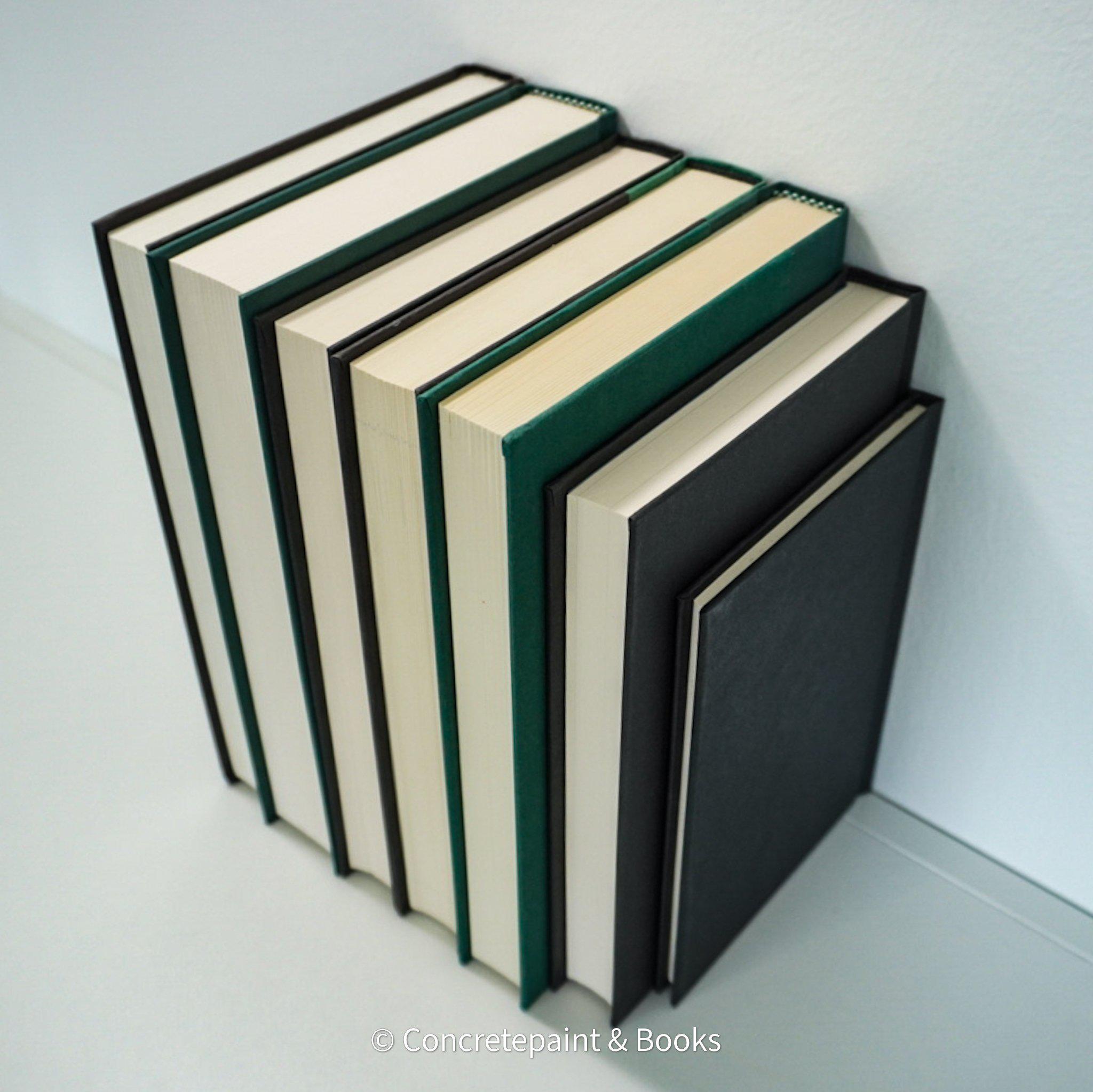 Black and green hardcover real books staged and used as home décor. Book stack on a shelf.