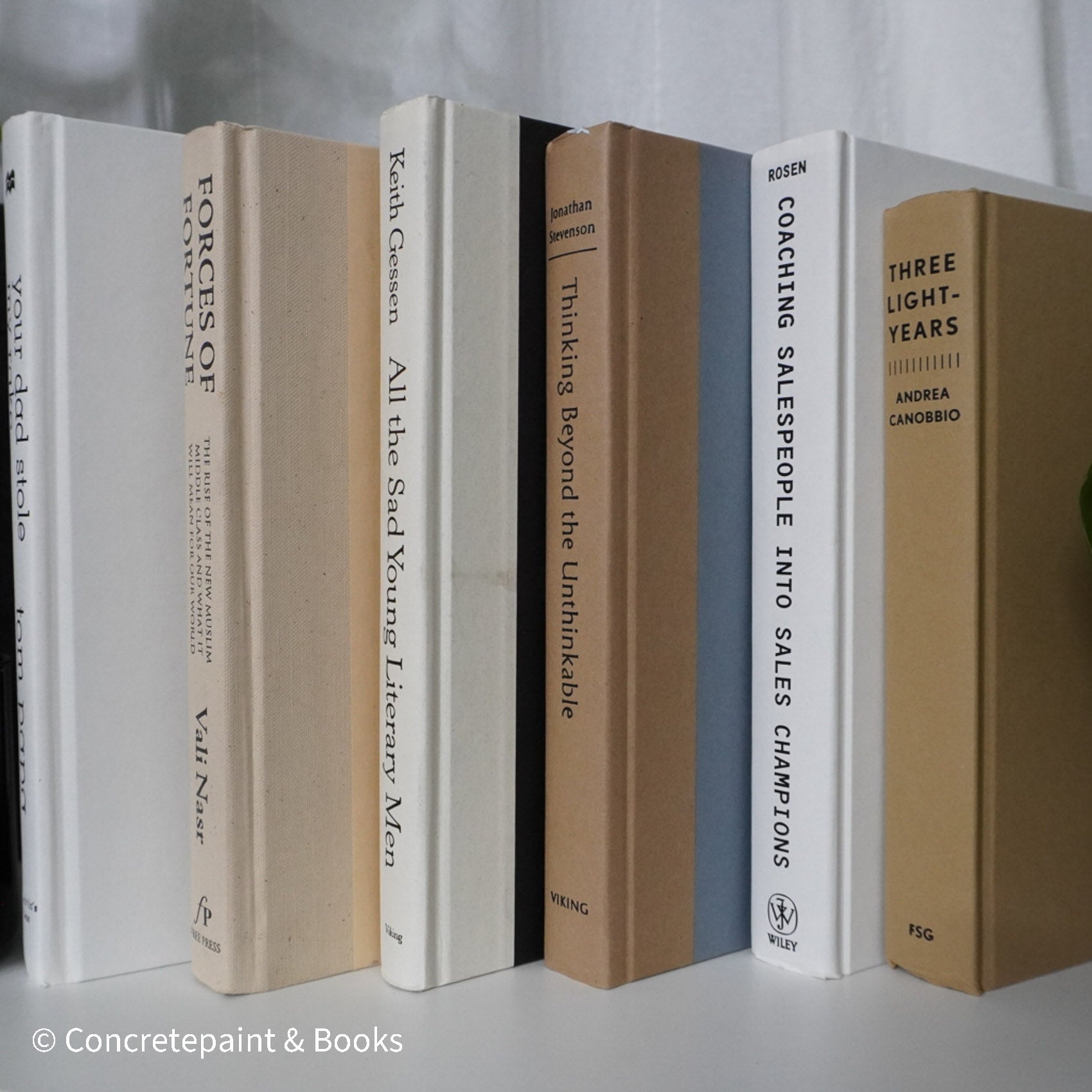 Neutral, sand and white books on display. Real hardcover books for decorating shelves.