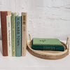 Set of real hardcover books stag3d and us3d as home decor. Decorative tray with green books on top. 