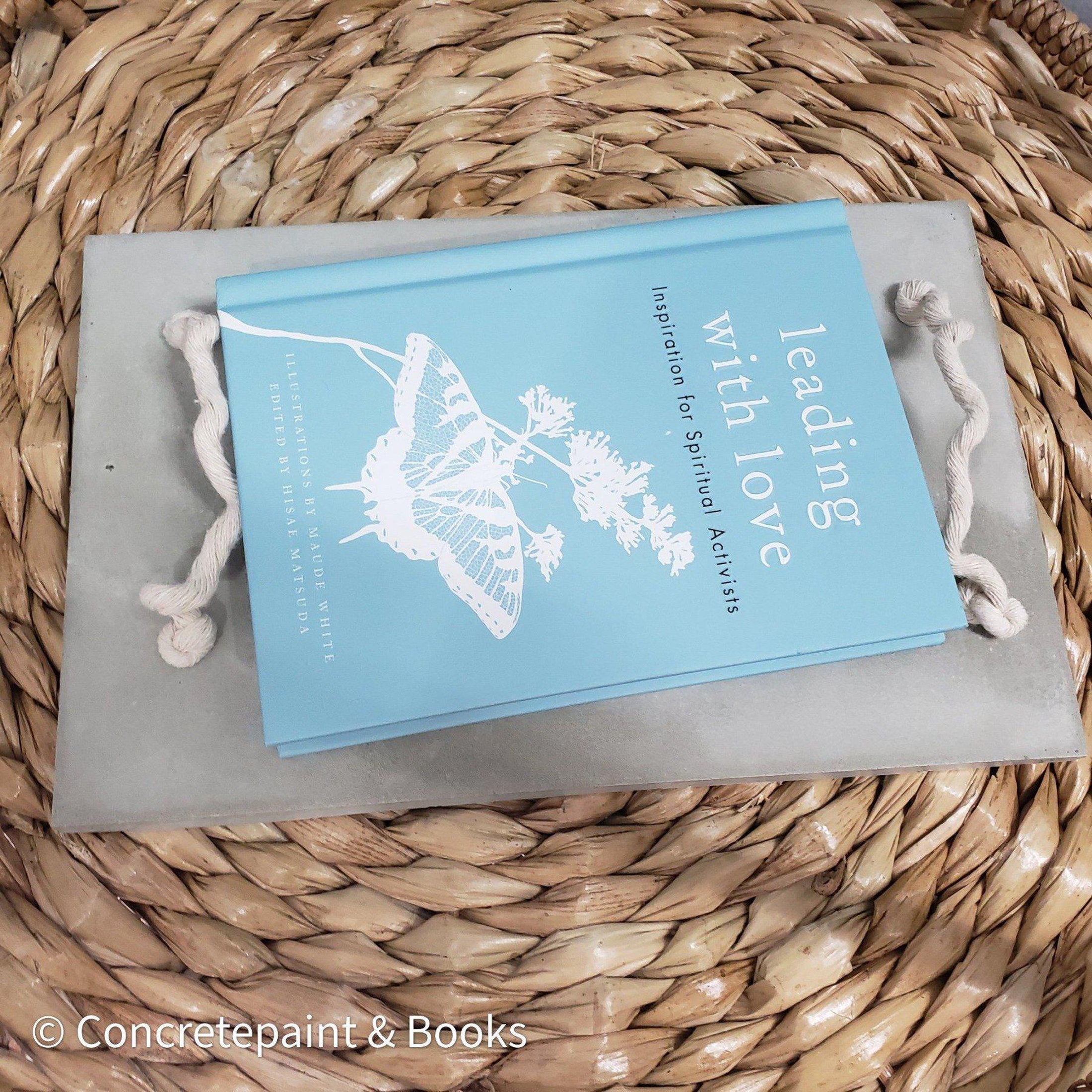 Decorative concrete tray with light blue hardcover book on top. Leading with Love Book and concrete home décor. 