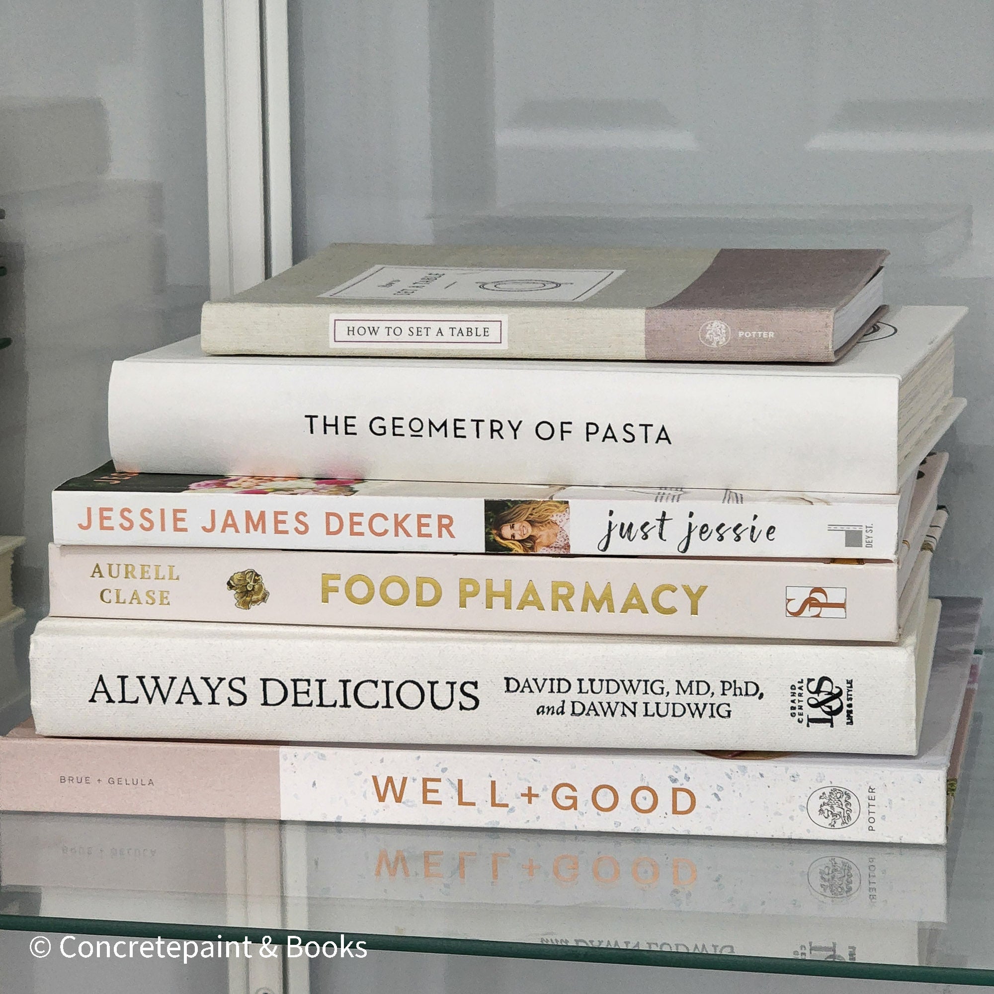 stack of white, neutral, and blush cookbooks on display.