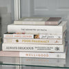 stack of white, neutral, and blush cookbooks on display.