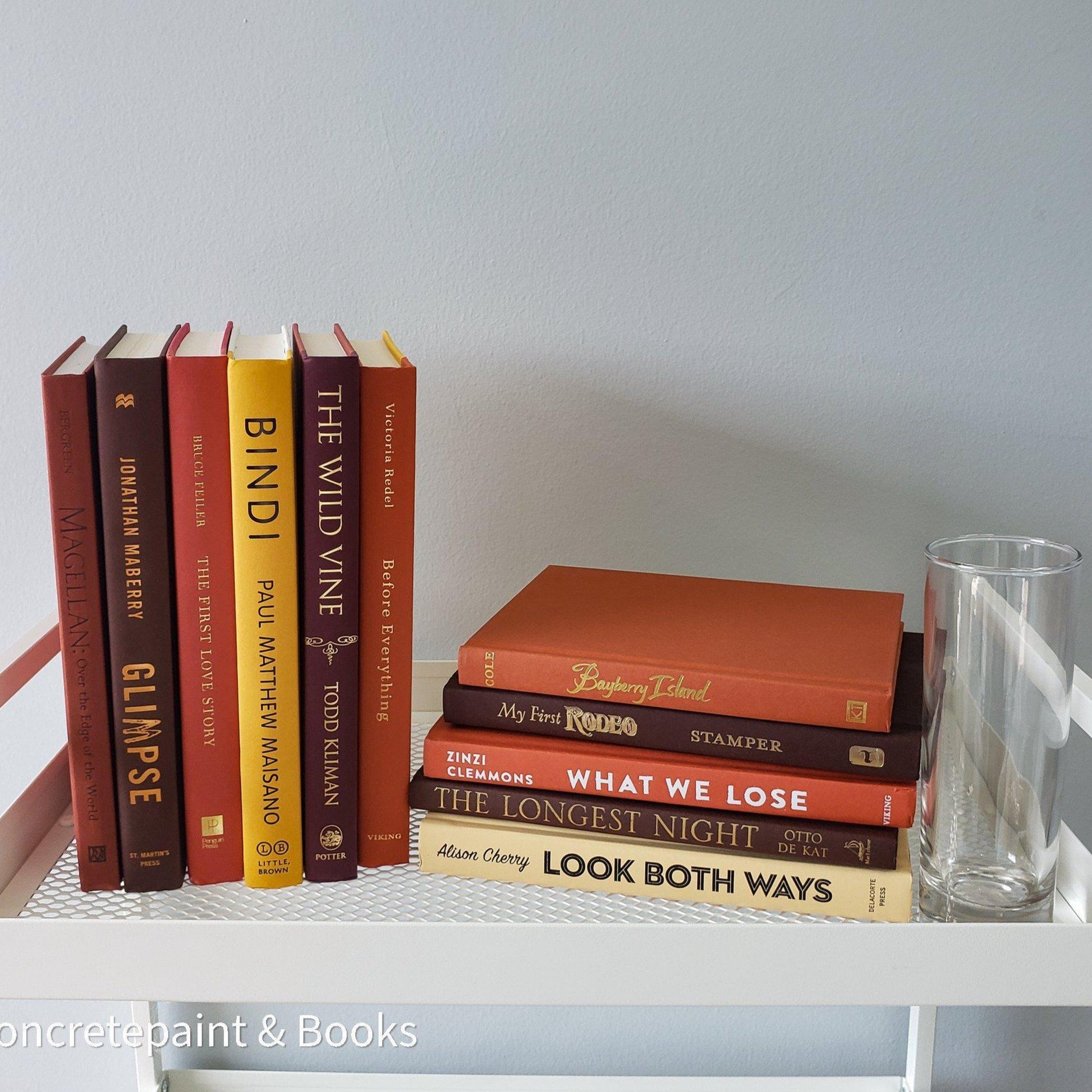 Yellow, orange, and brown books staged for display. Sets of rral hardcover books used for decorating.