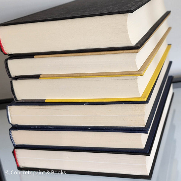 Stack of black blue and Gray books used as men's shelf decor.