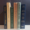 Neutral, mint, and navy color books used for decorating. Stack of real hardcover books for display. 