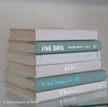 Mint green and white hardcover books on display. 