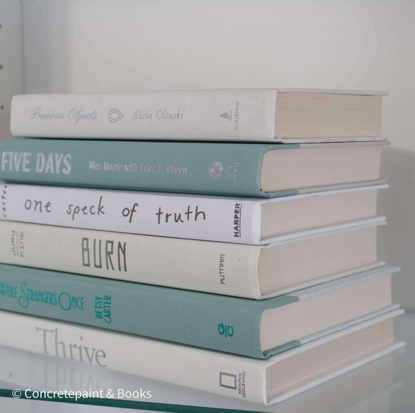 Mint green and white hardcover books on display. 