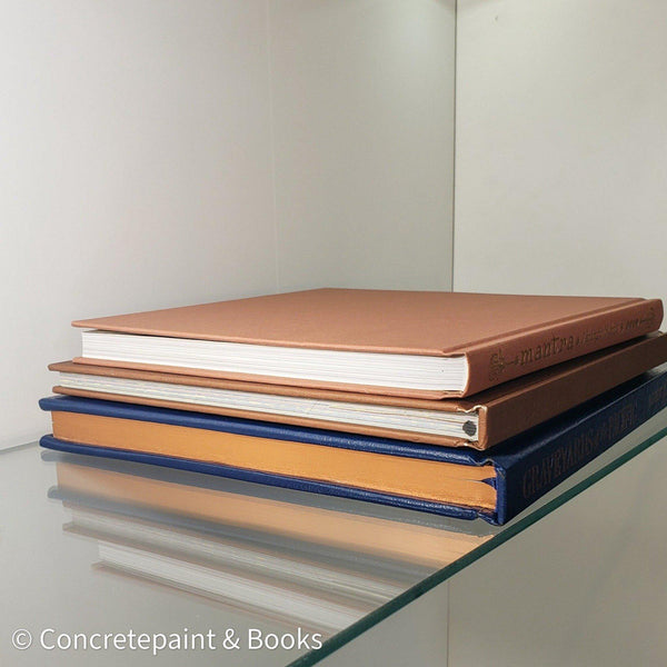 Stack of hardcover books in navy blue and neutral colors. Real books staged and used for decorating.