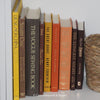 Set of decorative large books for display. Brown, yellow, and orange vintage books on bookshelf. 