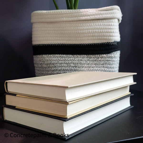 Real black and neutral headcover books used as staged home décor. Large coffee table books black and neutral with ikea bamboo bowl on top.